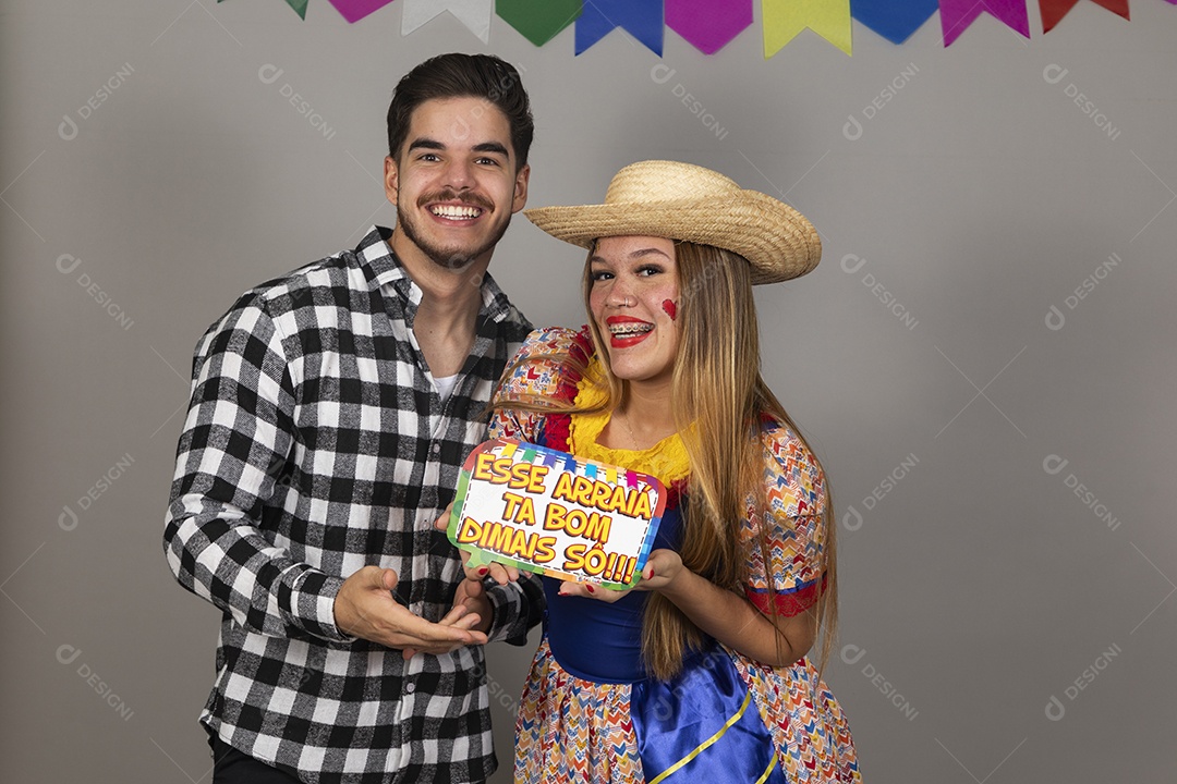 Lindo casal de jovens celebrando festa junina usando roupas típicas