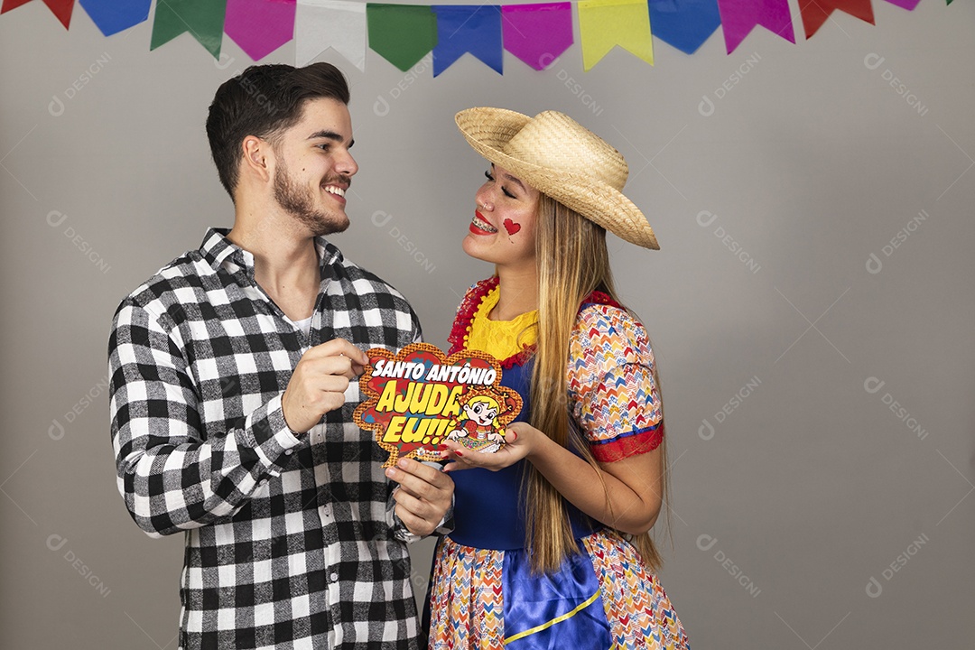 Lindo casal de jovens celebrando festa junina usando roupas típicas