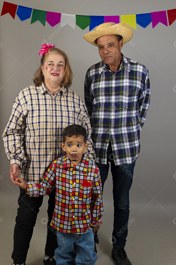 Lindo casal meia idade usando roupas típicas festa junina ao lado de seu neto