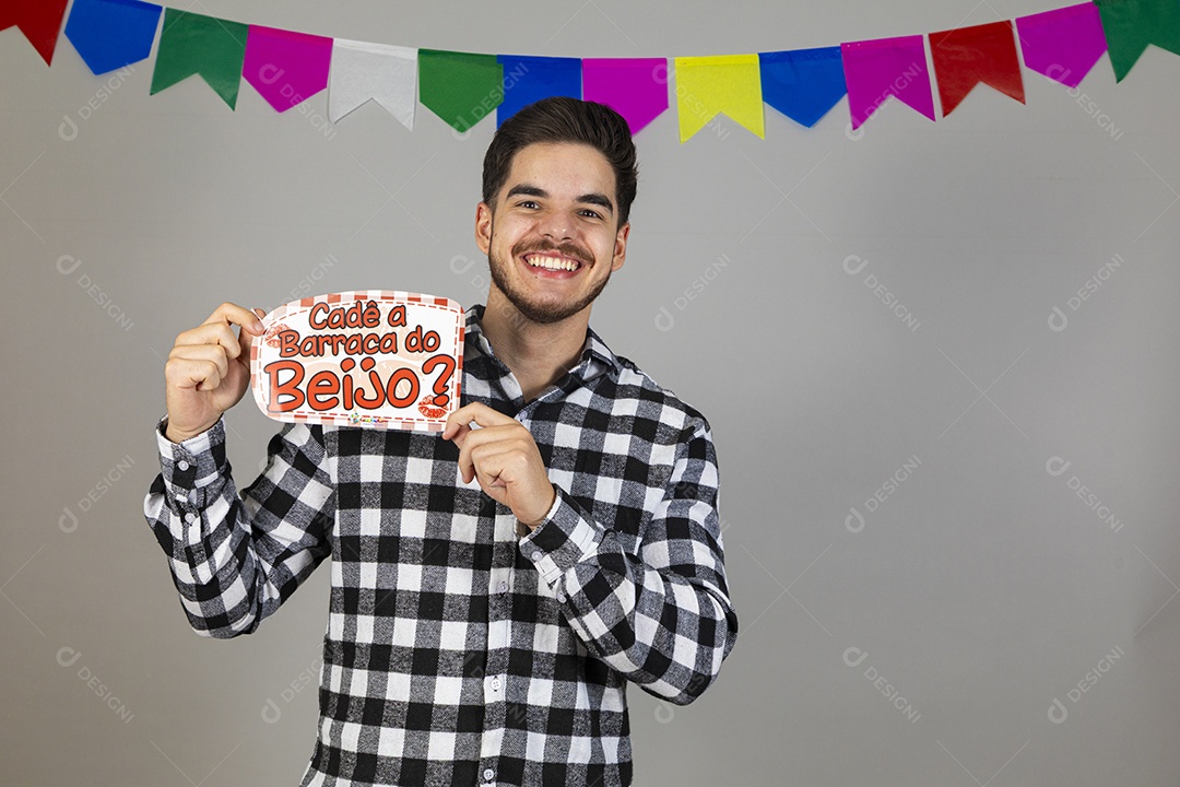 Homem jovem usando roupas típicas festa junina segurando placa