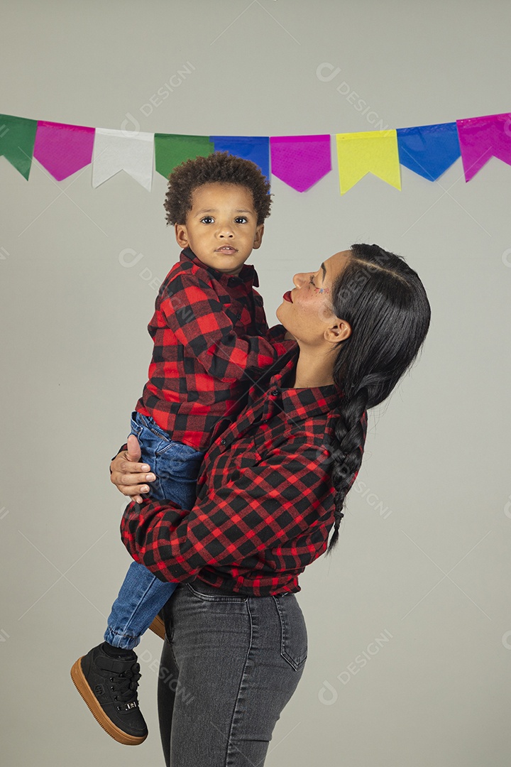 Mãe jovem usando roupas típicas festa junina sobre fundo isolado ao lado de seu filho