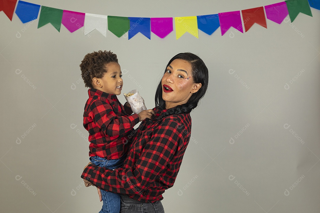 Mãe jovem usando roupas típicas festa junina sobre fundo isolado ao lado de seu filho