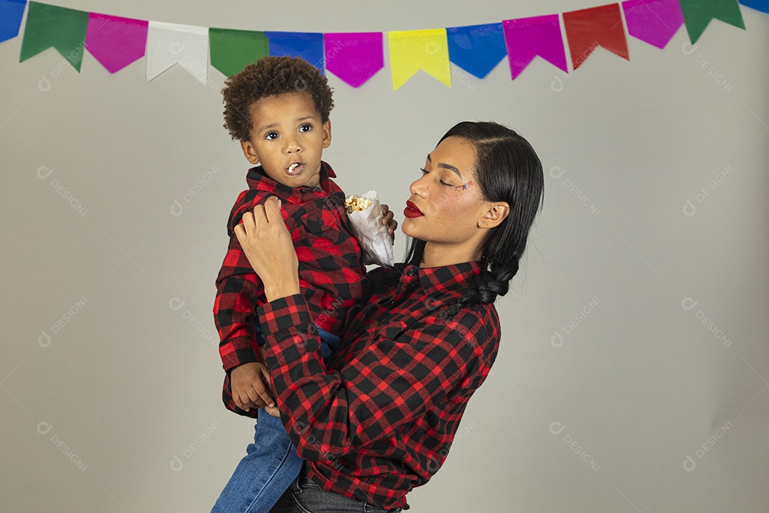 Mãe jovem usando roupas típicas festa junina sobre fundo isolado ao lado de seu filho