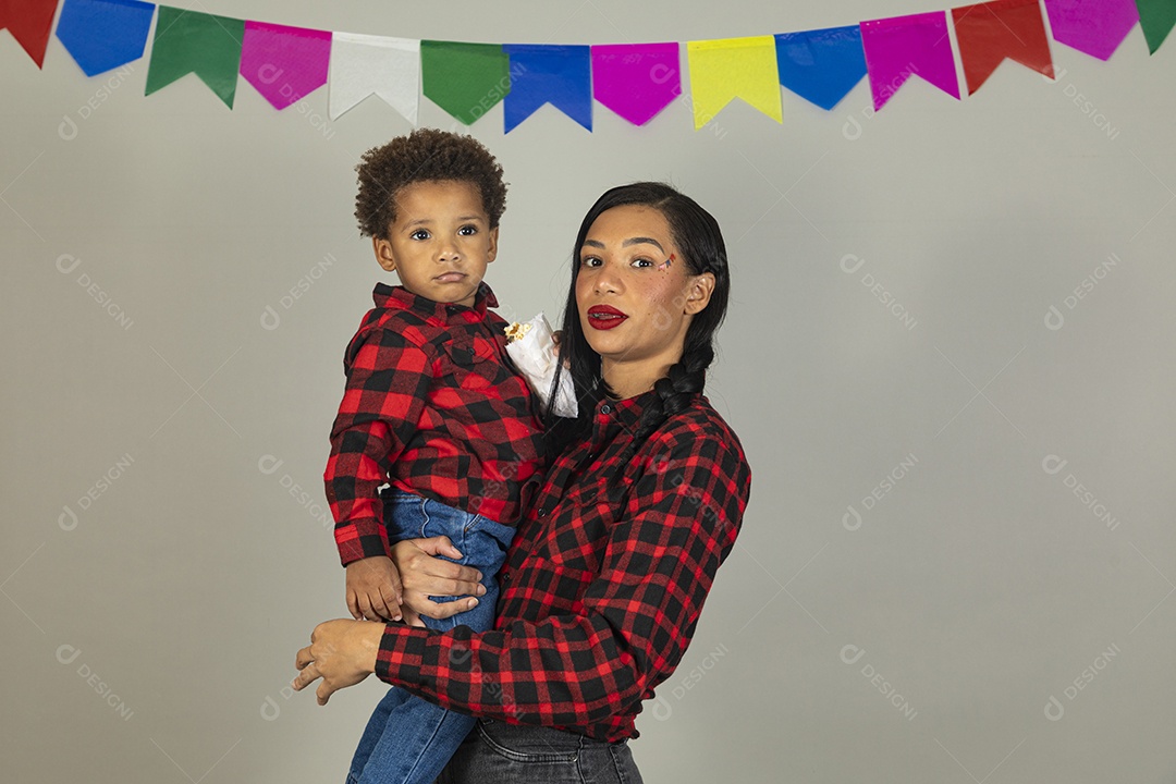 Mãe jovem usando roupas típicas festa junina sobre fundo isolado ao lado de seu filho