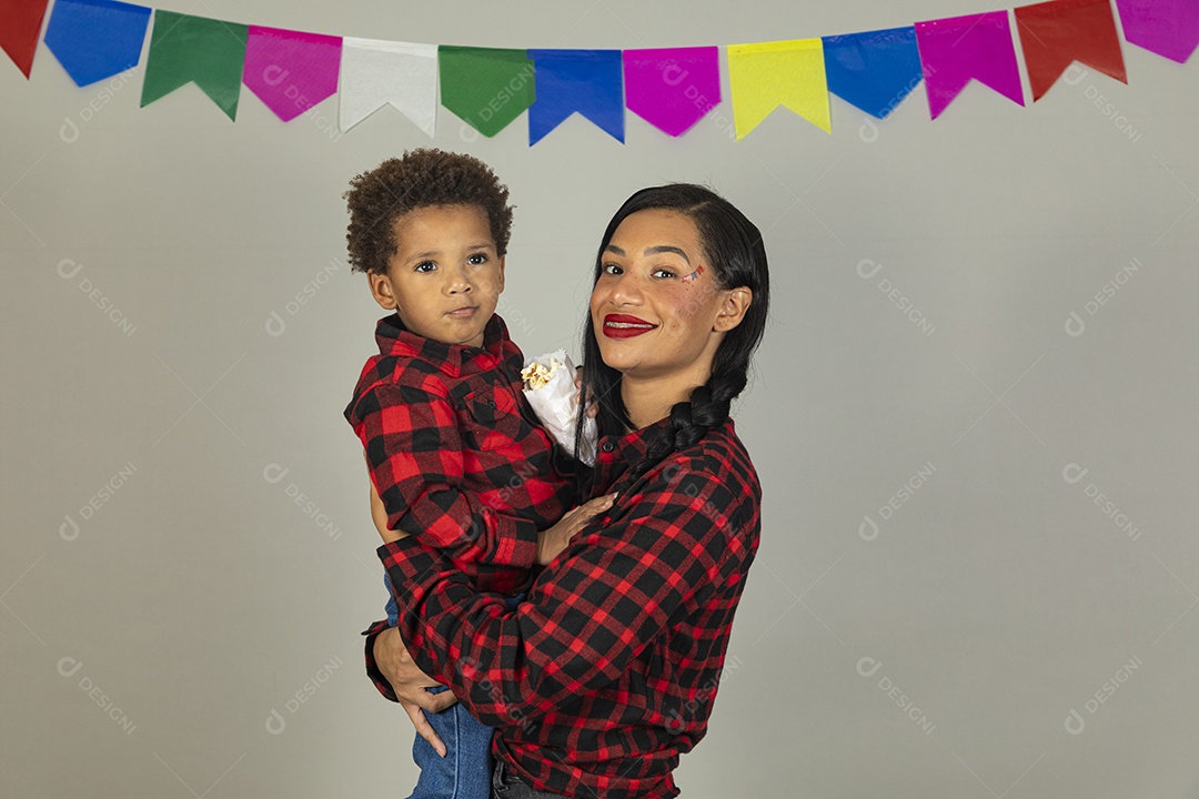 Mãe jovem usando roupas típicas festa junina sobre fundo isolado ao lado de seu filho