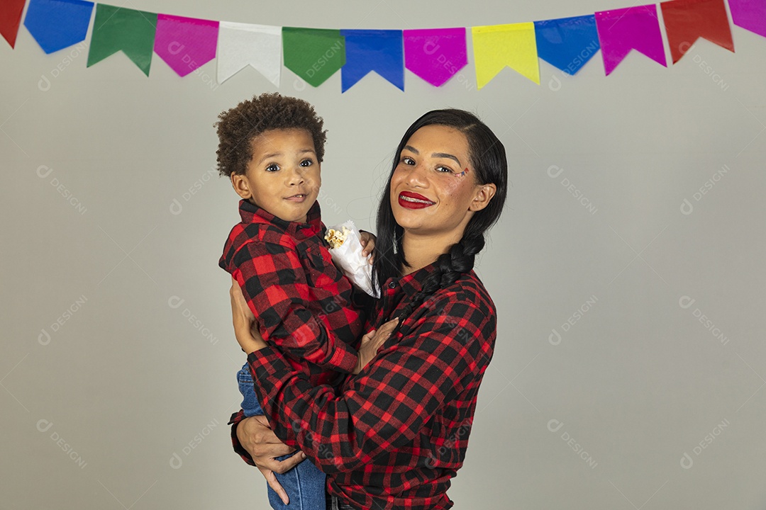 Mãe jovem usando roupas típicas festa junina sobre fundo isolado ao lado de seu filho