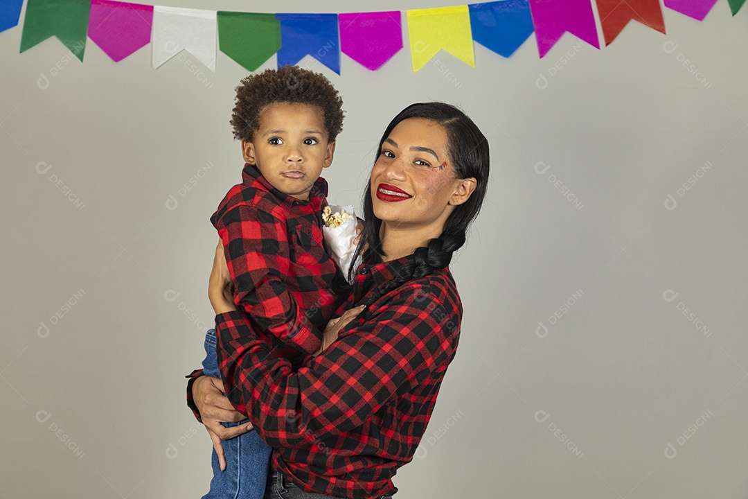 Mãe jovem usando roupas típicas festa junina sobre fundo isolado ao lado de seu filho