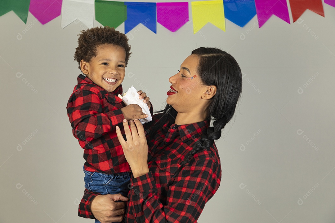 Mãe jovem usando roupas típicas festa junina sobre fundo isolado ao lado de seu filho