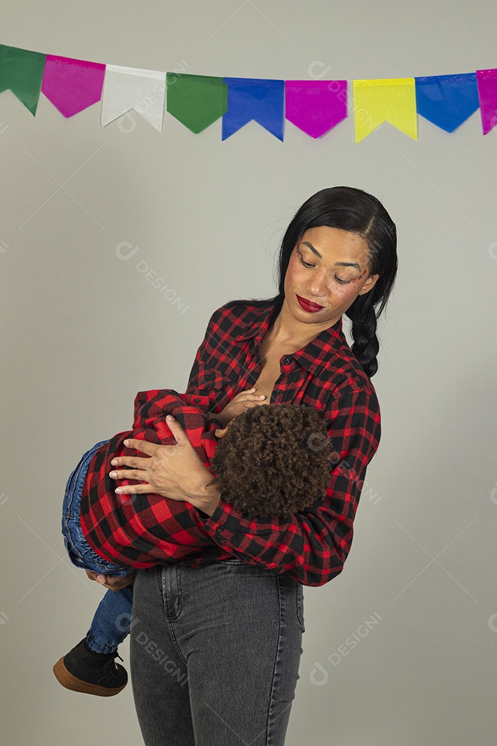 Mãe jovem usando roupas típicas festa junina sobre fundo isolado ao lado de seu filho