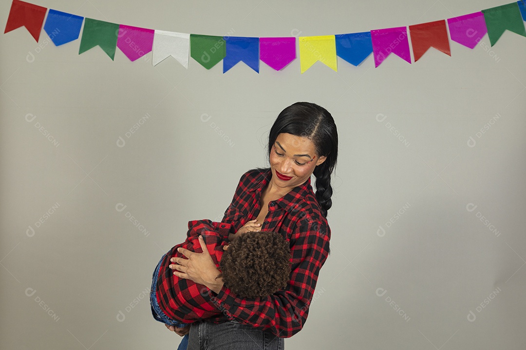 Mãe jovem usando roupas típicas festa junina sobre fundo isolado ao lado de seu filho