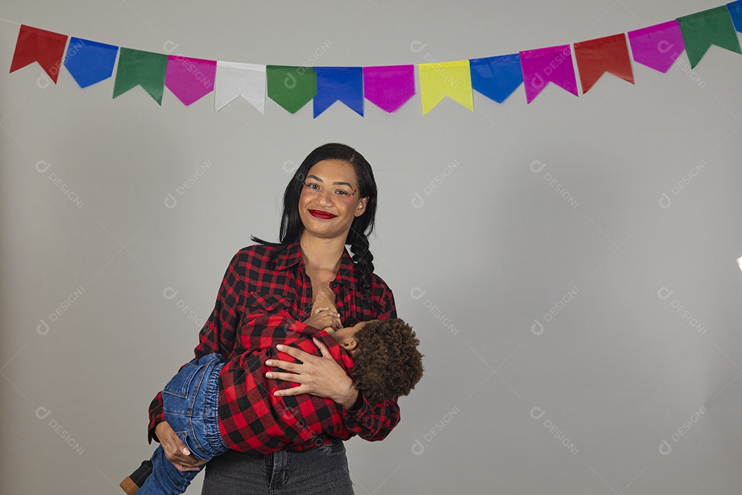 Mãe jovem usando roupas típicas festa junina sobre fundo isolado ao lado de seu filho