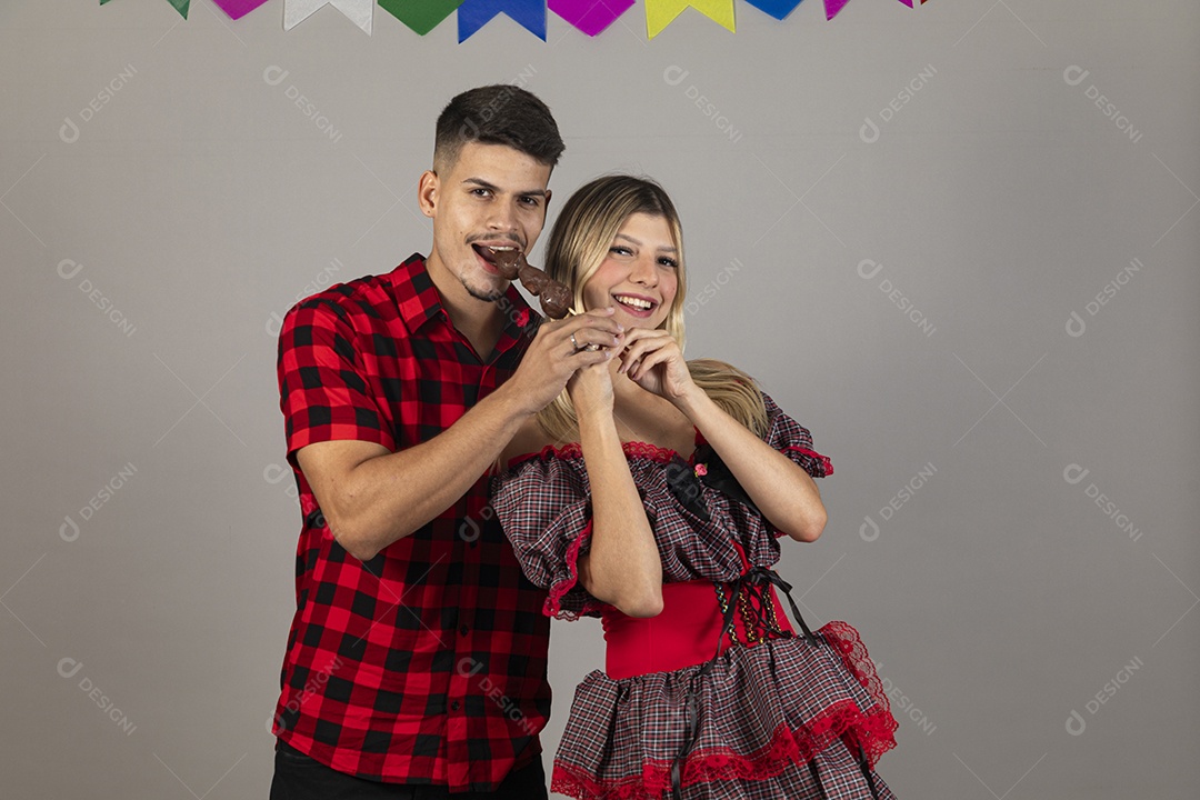 Lindo casal de jovens celebrando festa junina usando roupas típicas de São João