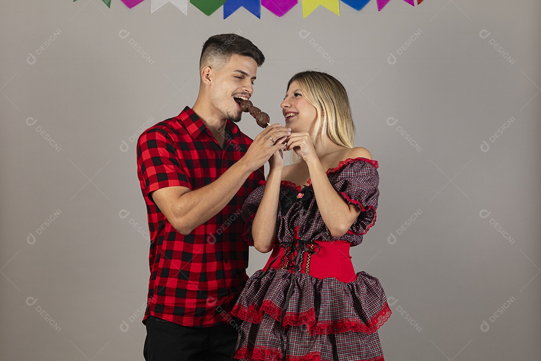 Lindo casal de jovens celebrando festa junina usando roupas típicas de São João