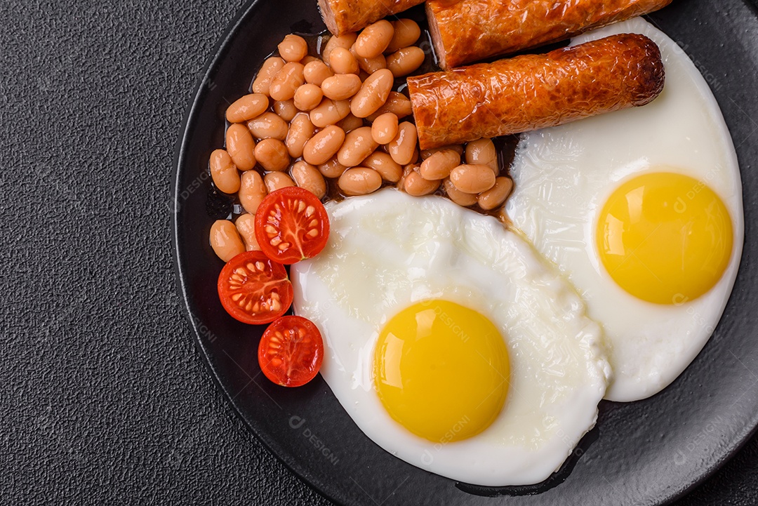 Prato de comida linguiça e ovo frito feijão mesa concreto