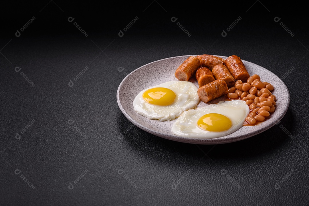 Prato de comida linguiça e ovo frito feijão mesa concreto