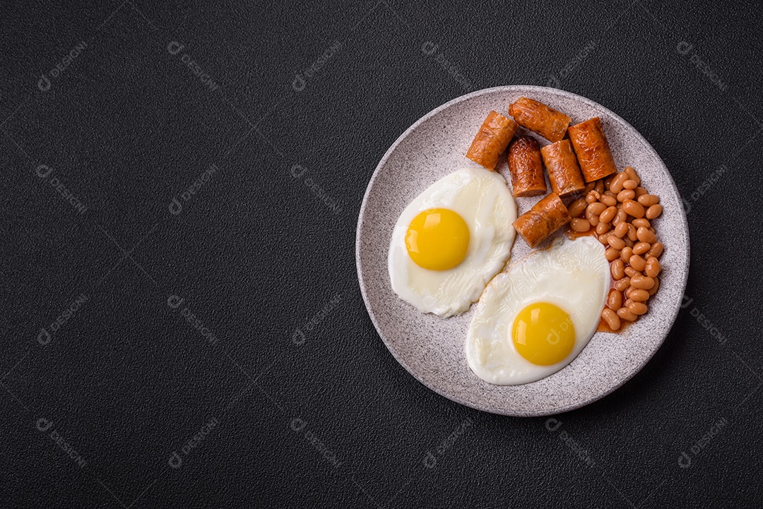 Prato de comida linguiça e ovo frito feijão mesa concreto