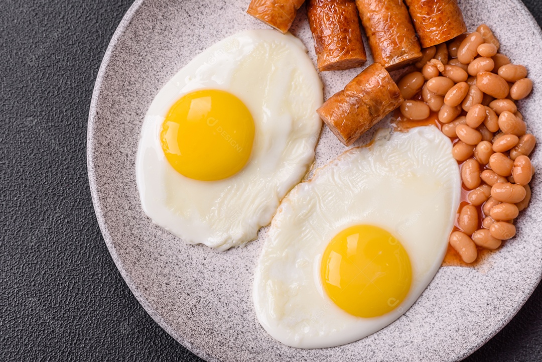 Prato de comida linguiça e ovo frito feijão mesa concreto