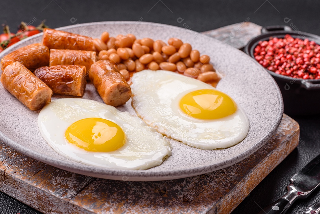 Prato de comida linguiça e ovo frito feijão mesa concreto
