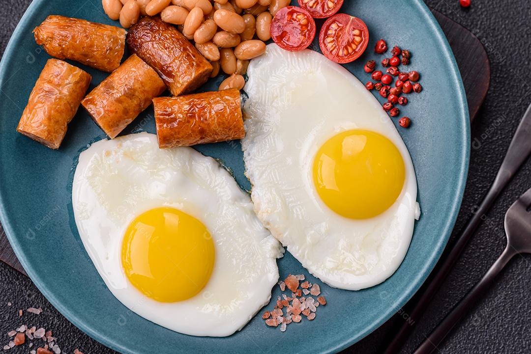 Prato de comida linguiça e ovo frito feijão mesa concreto