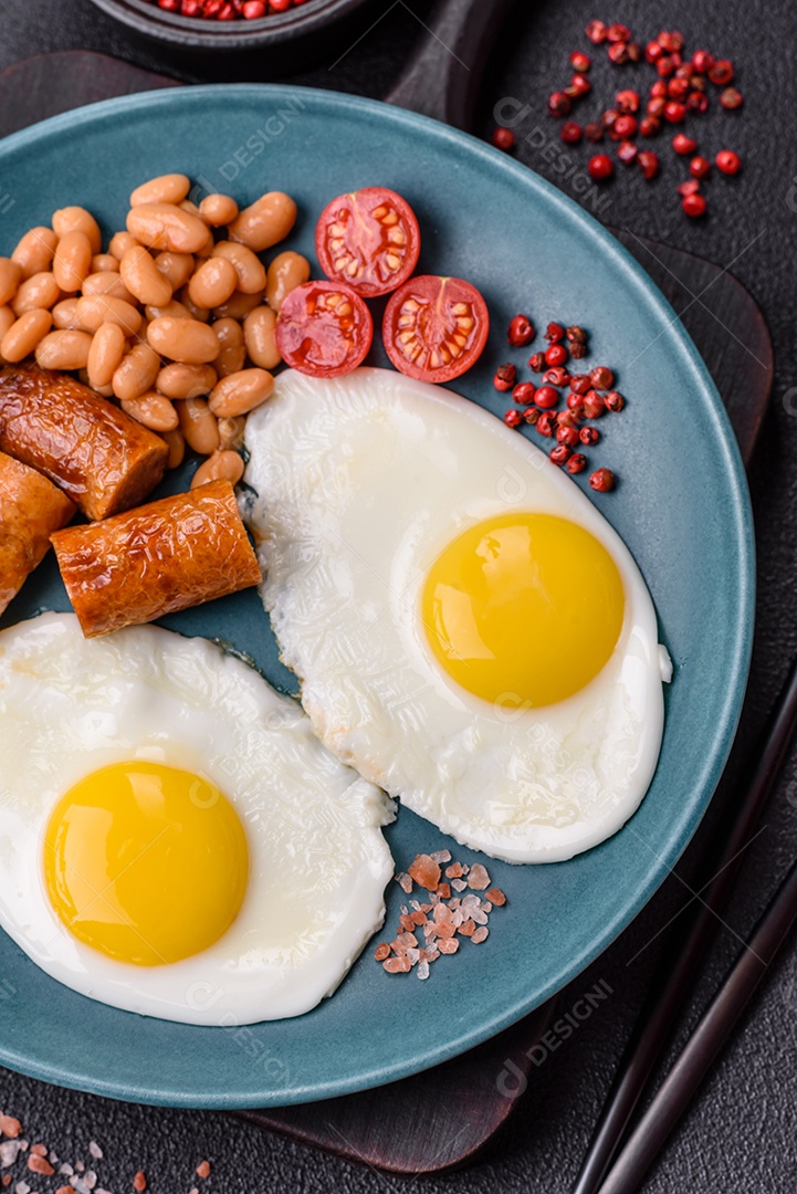 Prato de comida linguiça e ovo frito feijão mesa concreto