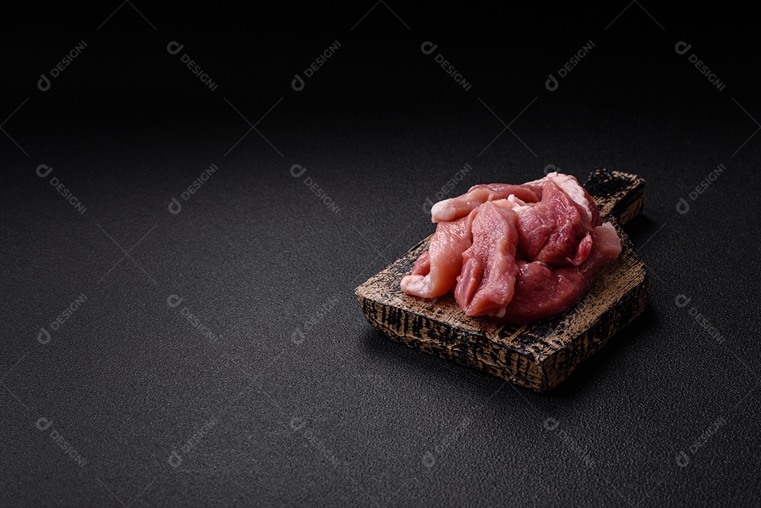 Carnes crua cortadas em fatias em uma mesa de concreto