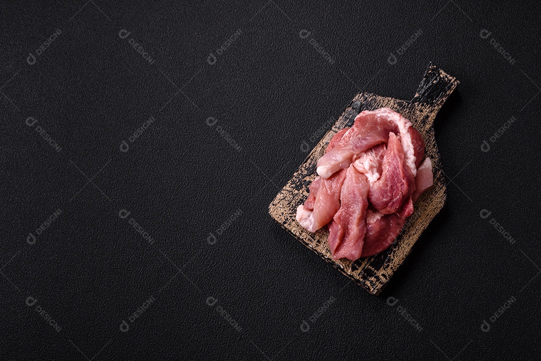 Carnes crua cortadas em fatias em uma mesa de concreto