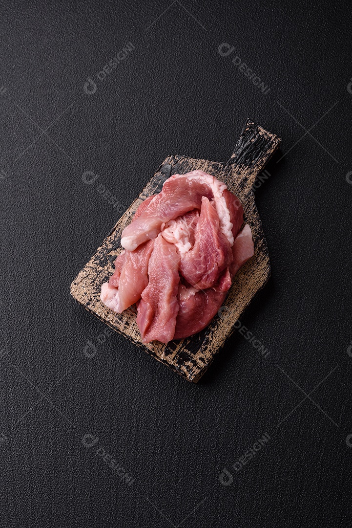 Carnes crua cortadas em fatias em uma mesa de concreto