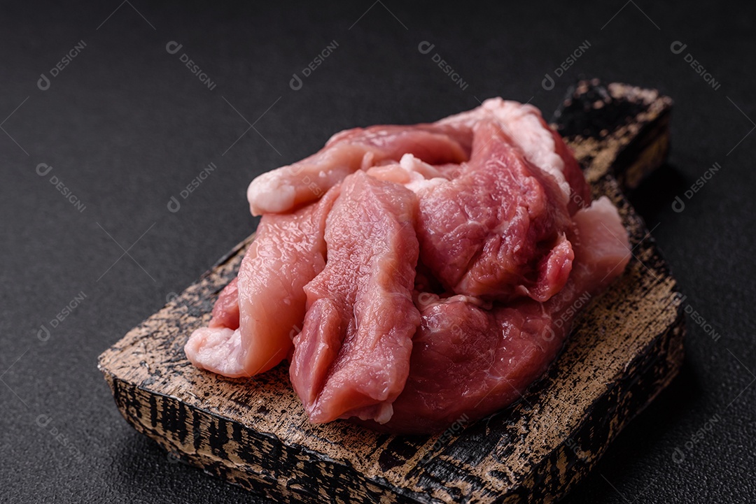 Carnes crua cortadas em fatias em uma mesa de concreto