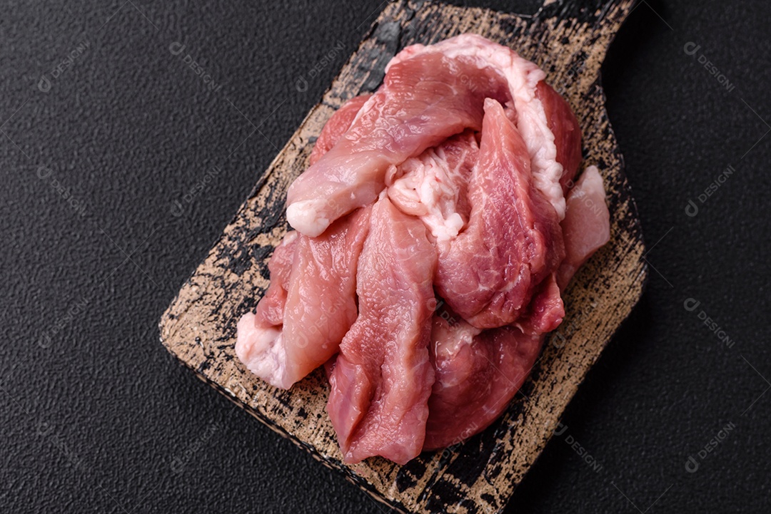 Carnes crua cortadas em fatias em uma mesa de concreto