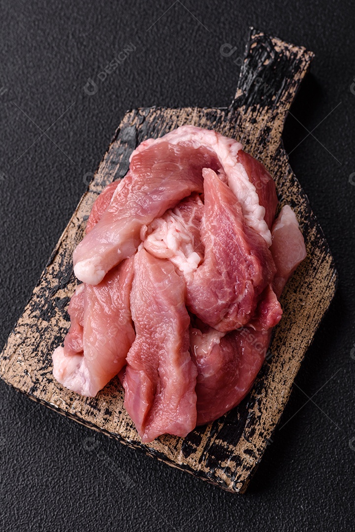 Carnes crua cortadas em fatias em uma mesa de concreto