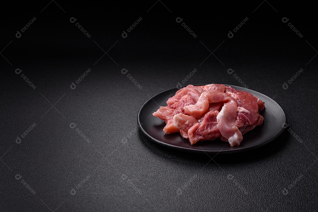 Carnes crua cortadas em fatias em uma mesa de concreto