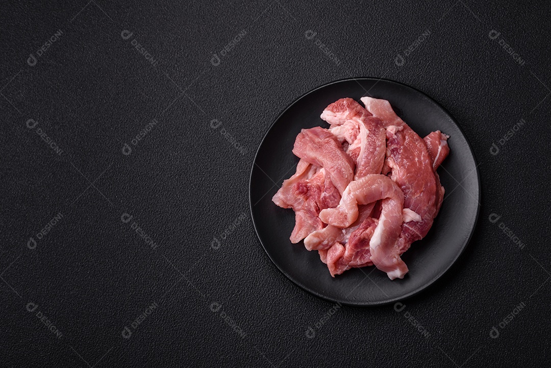Carnes crua cortadas em fatias em uma mesa de concreto