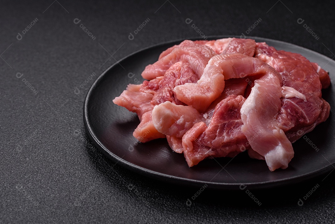 Carnes crua cortadas em fatias em uma mesa de concreto