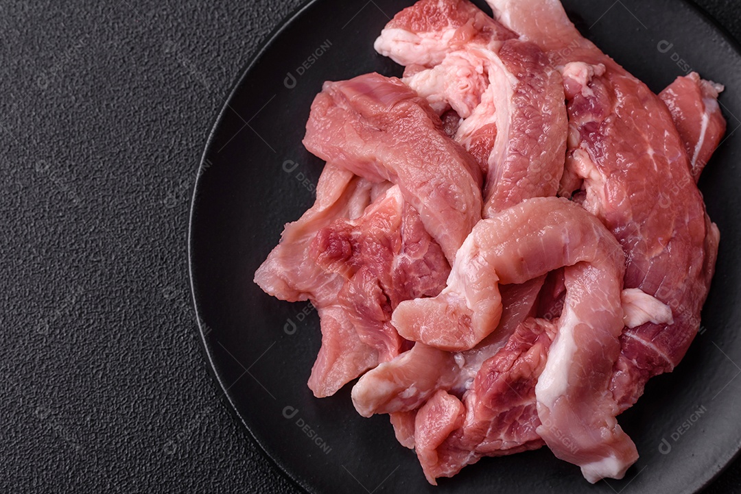 Carnes crua cortadas em fatias em uma mesa de concreto
