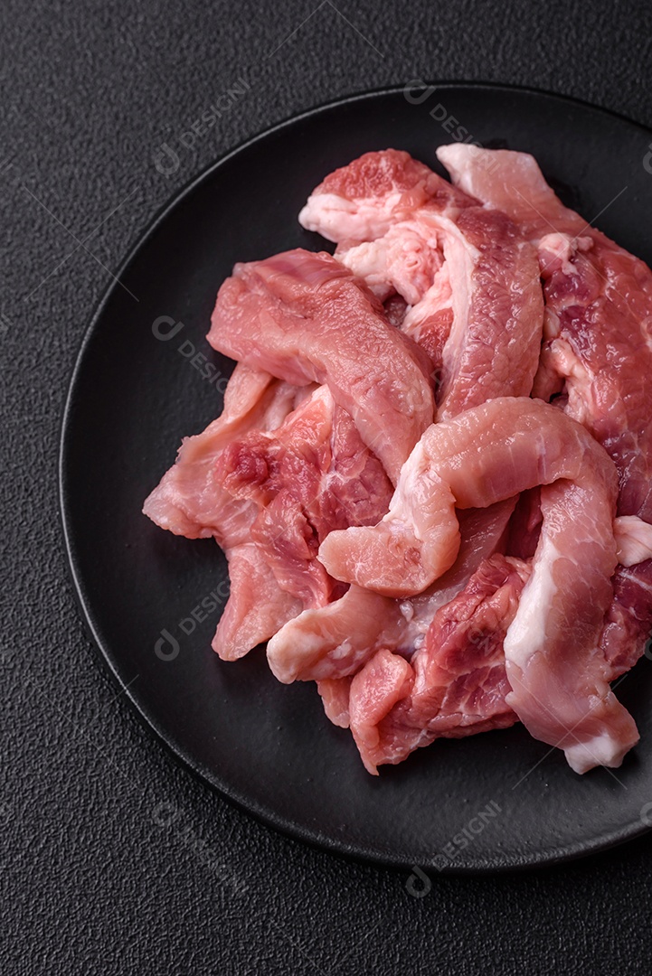 Carnes crua cortadas em fatias em uma mesa de concreto