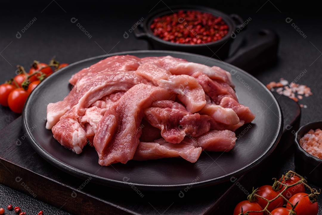 Carnes crua cortadas em fatias em uma mesa de concreto