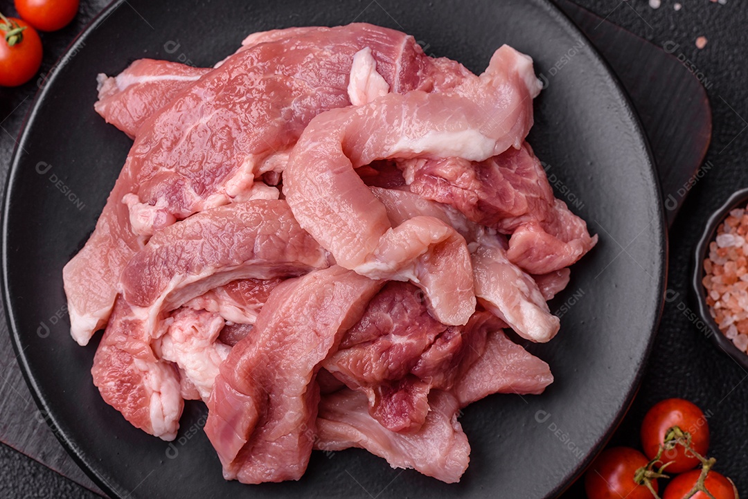 Carnes crua cortadas em fatias em uma mesa de concreto