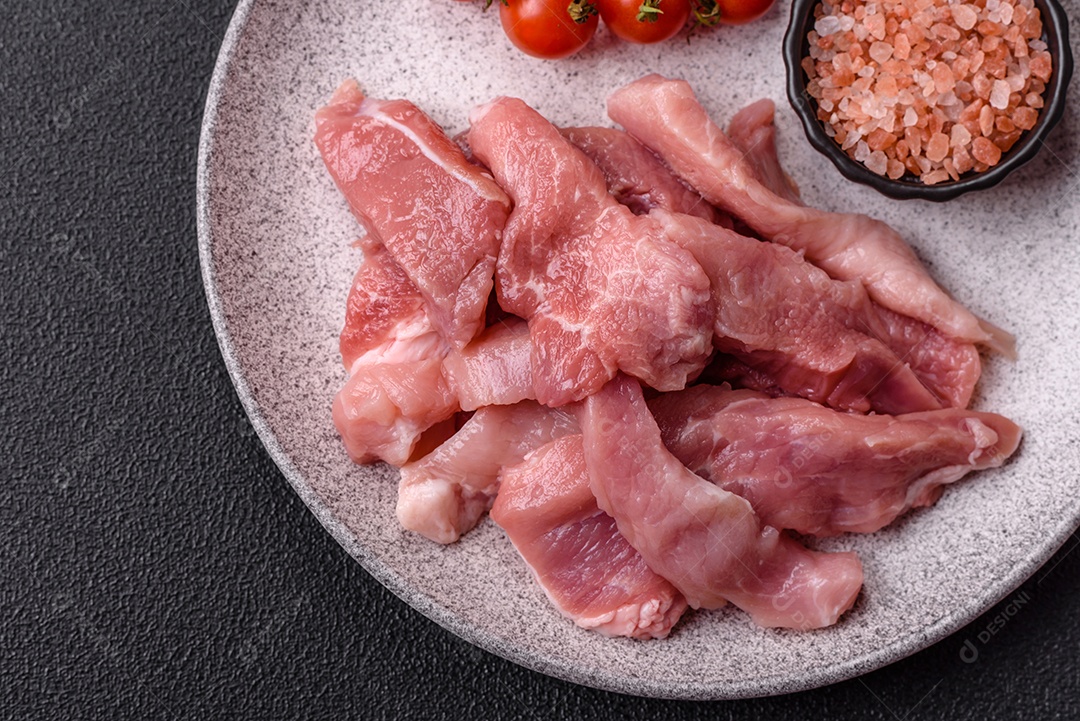 Carnes crua cortadas em fatias em uma mesa de concreto
