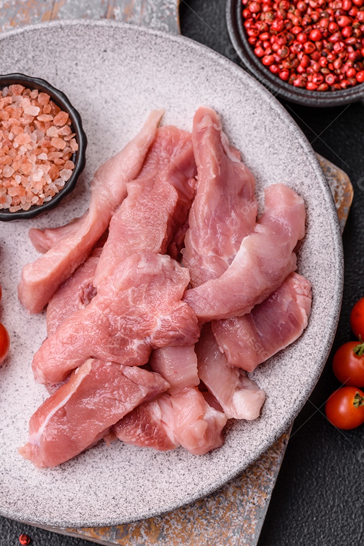 Carnes crua cortadas em fatias em uma mesa de concreto
