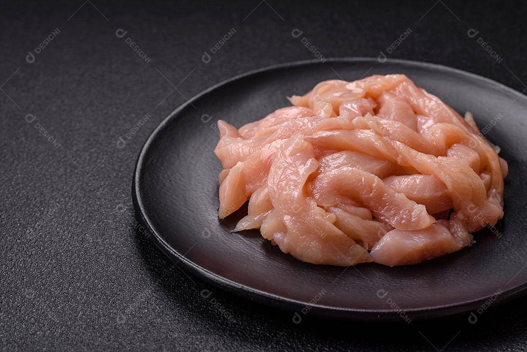 Filé de frango cru cortado em tiras com especiarias e ervas