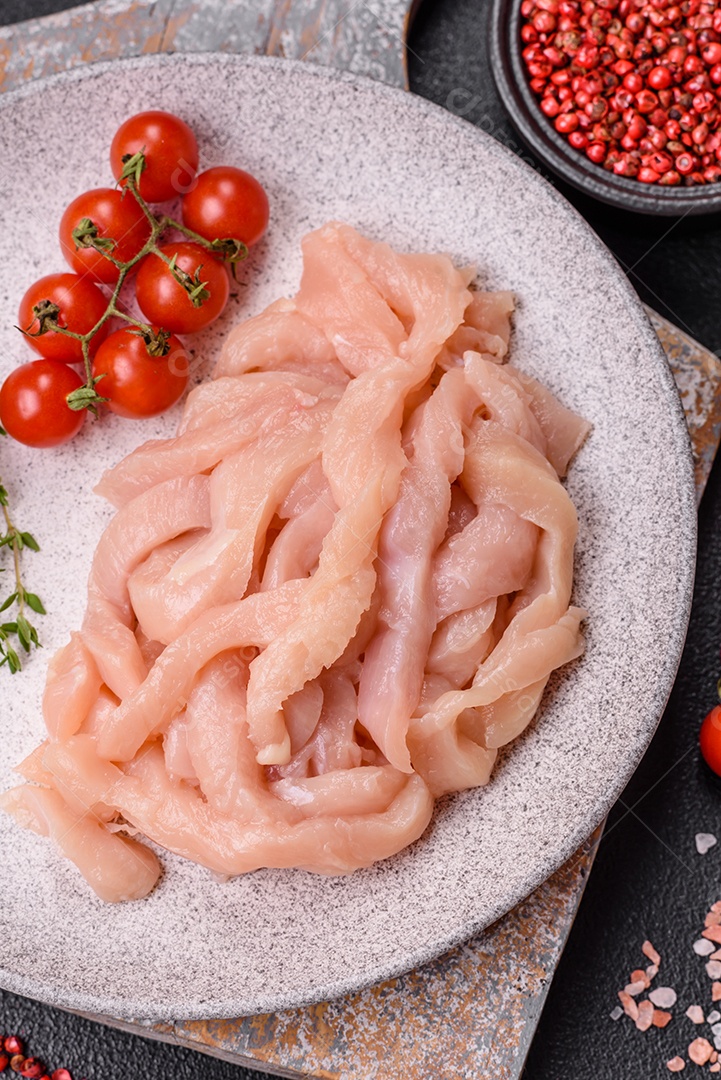 Filé de frango cru cortado em tiras com especiarias e ervas