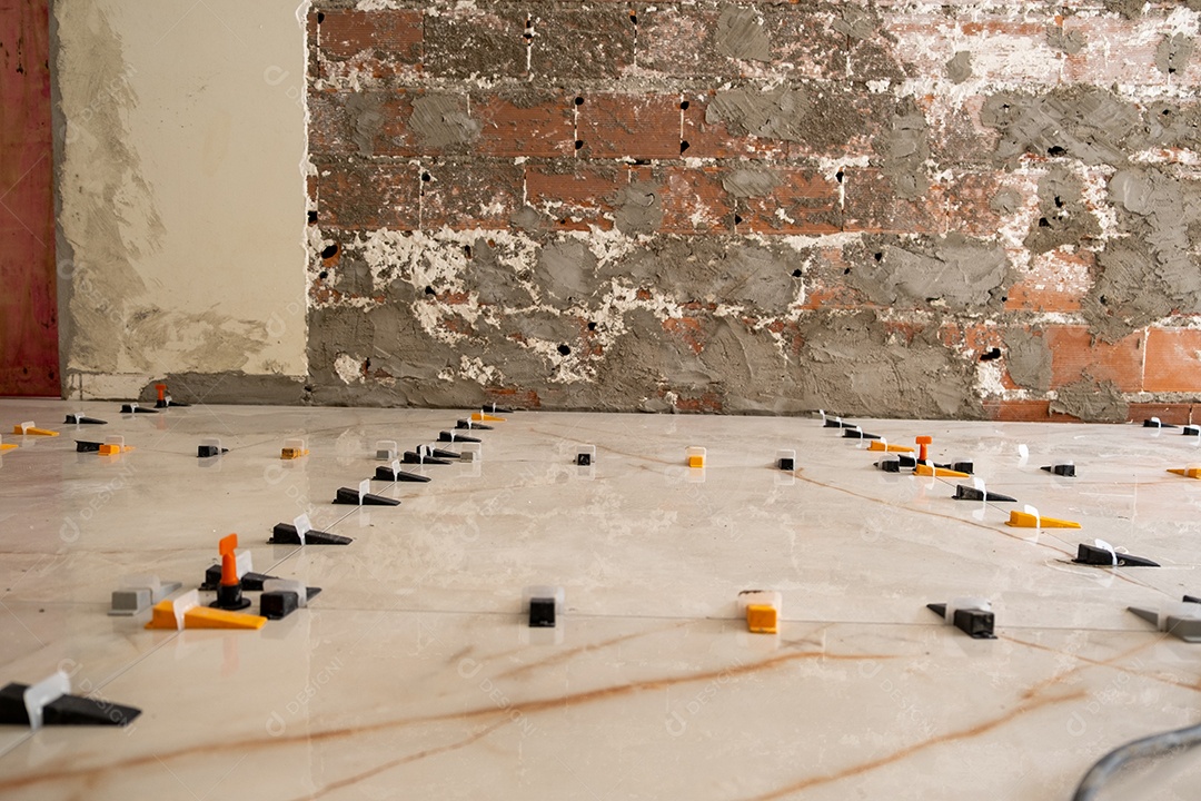 Trabalhador instalando piso cerâmico em obra residencial Imagem JPG