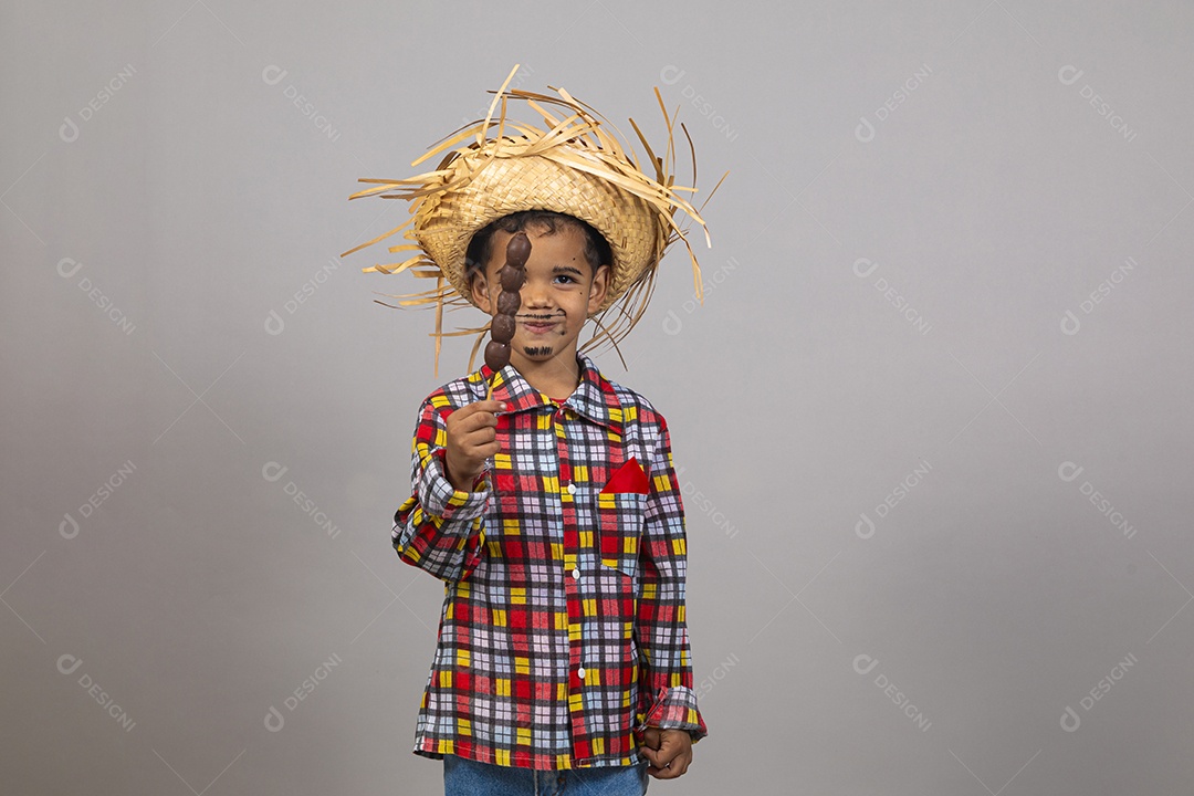Lindo garotinho usando roupas típicas festa junina se alimentando
