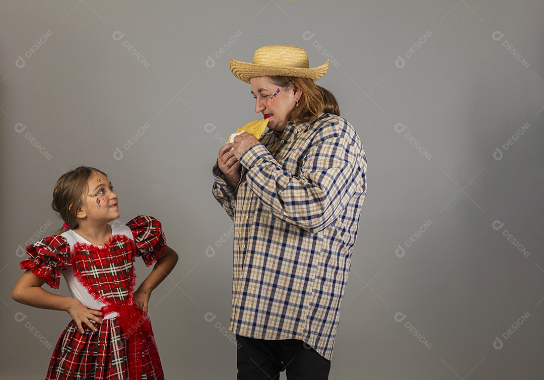 Avó ao lado de seus netq celebrando festa junina usando roupas e trajes típicos