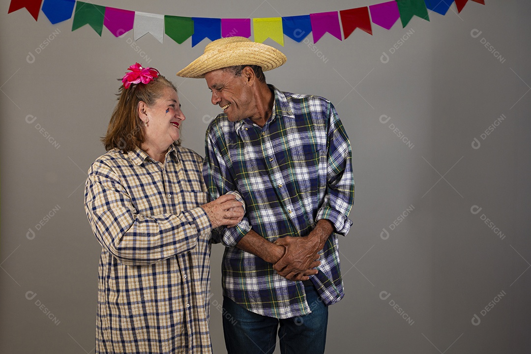 Avó ao lado de seus netos celebrando festa junina usando roupas e trajes típicos