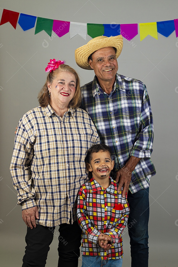Avós feliz e sorridente celebrando festa junina com seu neto