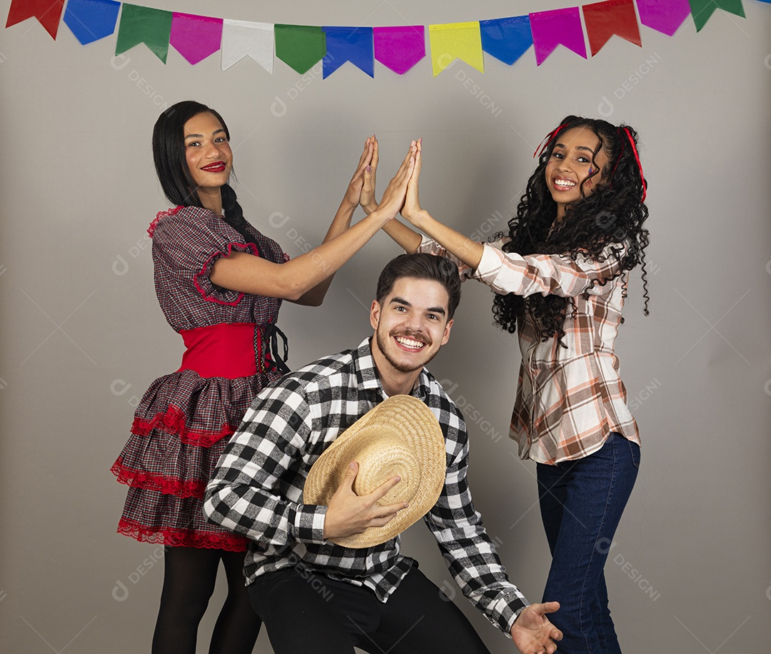 Grupo de jovens usando roupas típicas de festa junina sobre fundo isolado