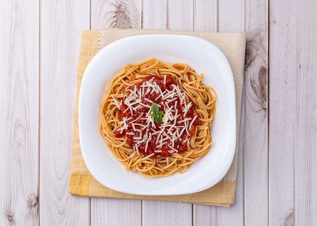 Imagem mostra um prato de espaguete com molho vermelho e queijo ralado por cima