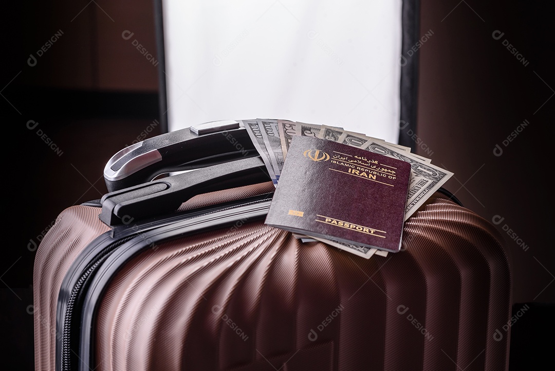 Passaporte sobre uma mala de viagem ao lado de dinheiro