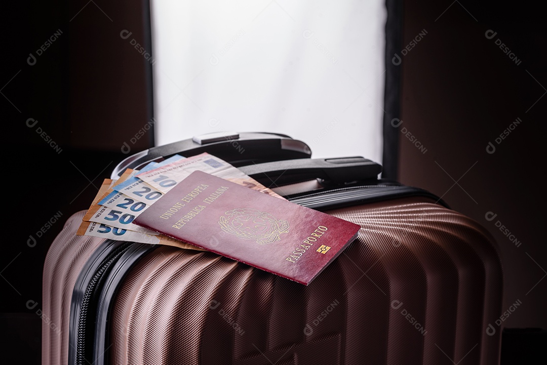 Passaporte sobre uma mala de viagem ao lado de dinheiro